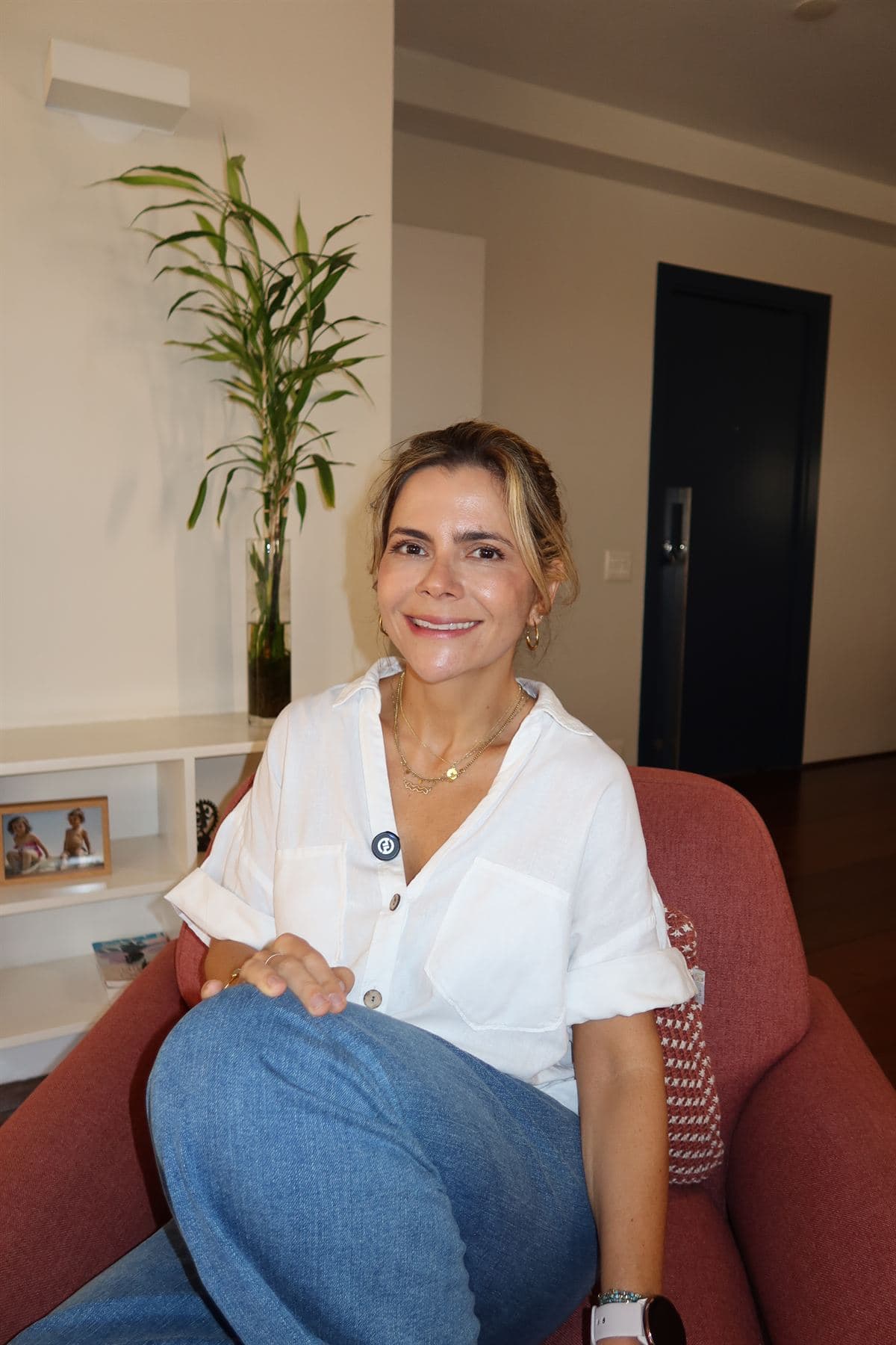 Paula Braga sorrindo, sentada na poltrona do consultório
